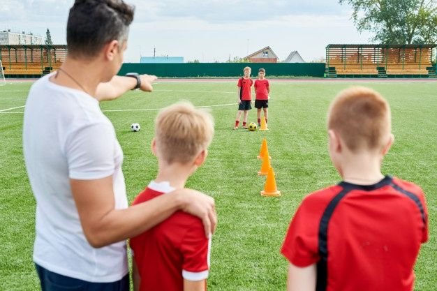 Premium Photo _ Junior Football team Practicing in Field